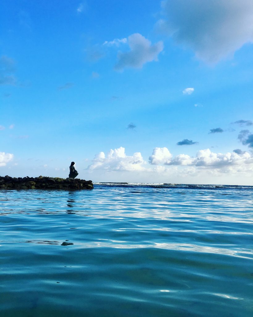 Woman siting alone on the beach in Roatan