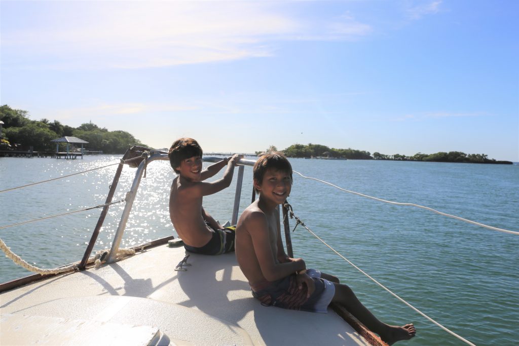 Two boys sitting on the bow of a boat