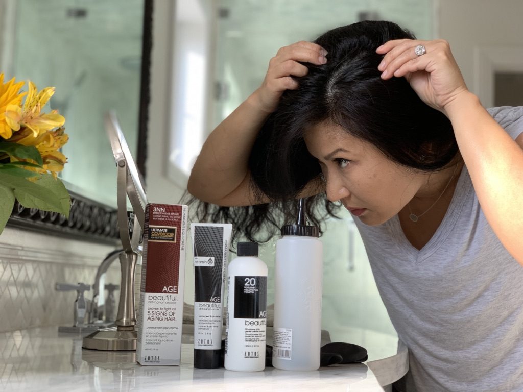 woman looking at gray hair with agebeautiful products on display