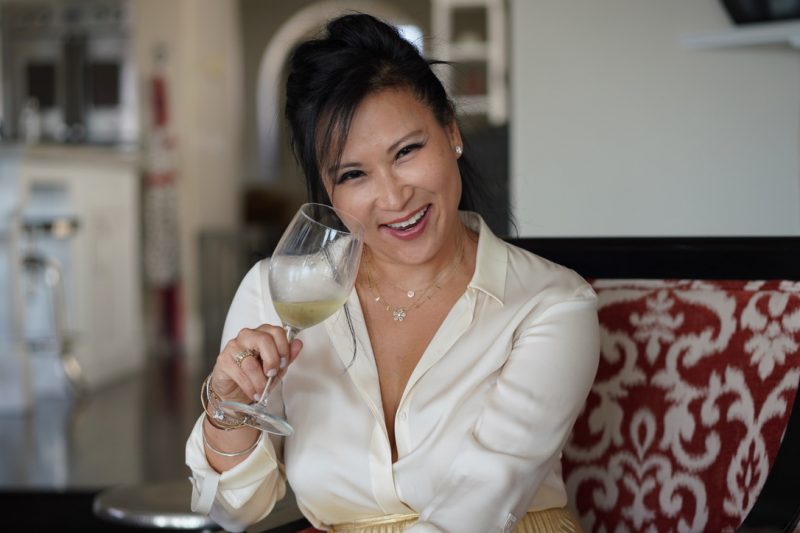 woman smiling with glass of white wine