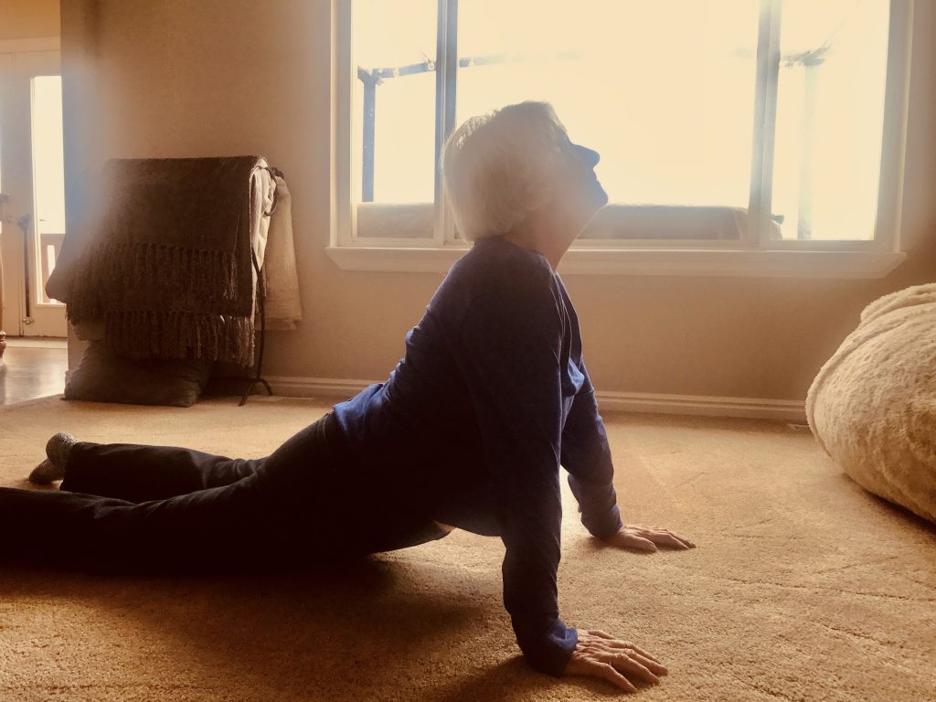 senior doing yoga in living room