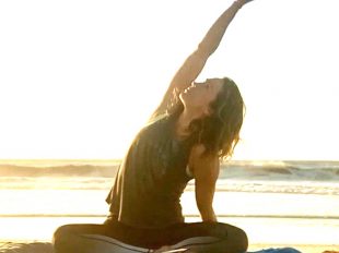 woman doing yoga on beach