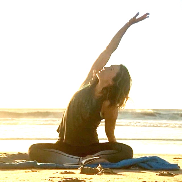 woman doing yoga on beach